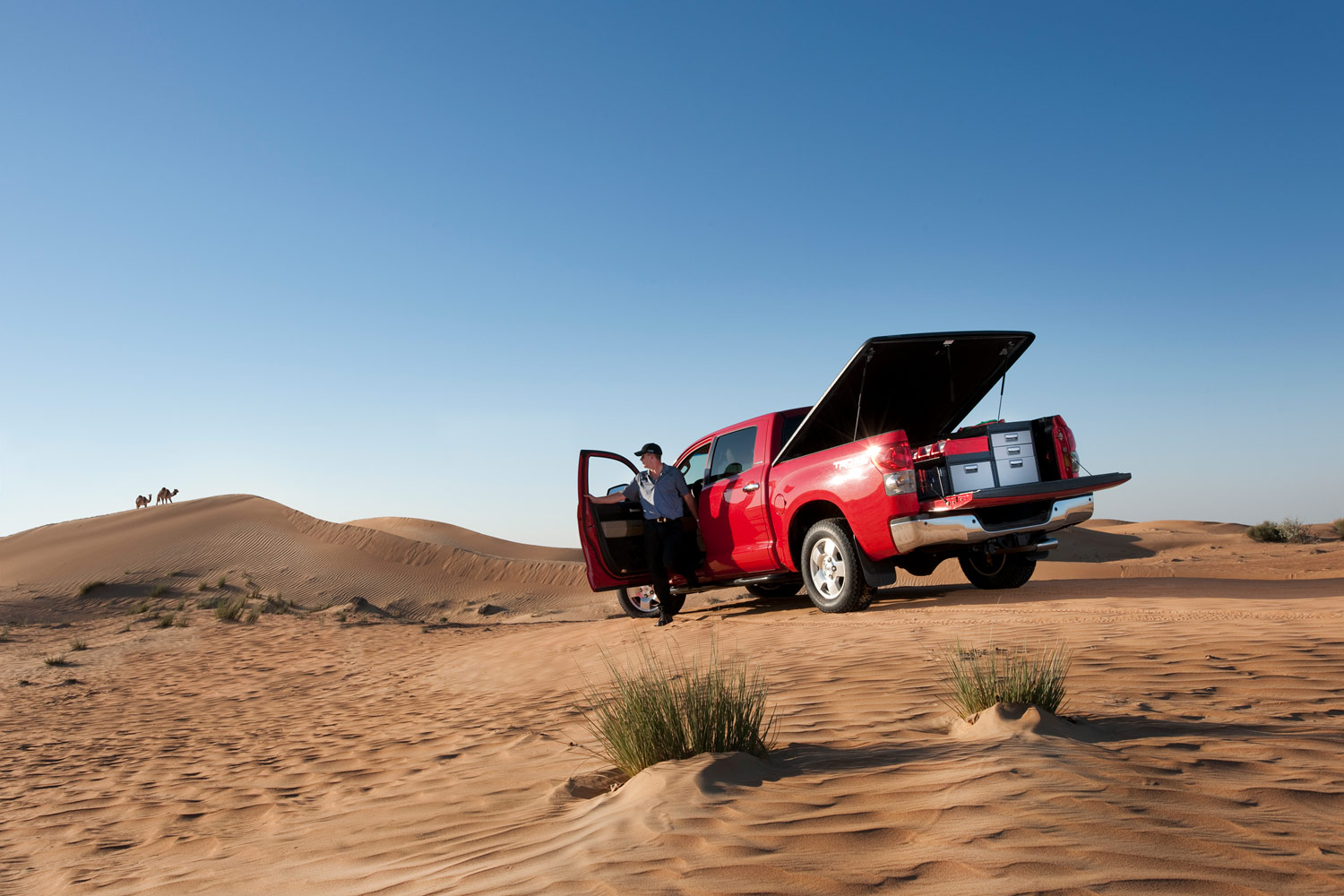 Arbetarens röda pickup truck med bilinredning från Modul-System i en öken