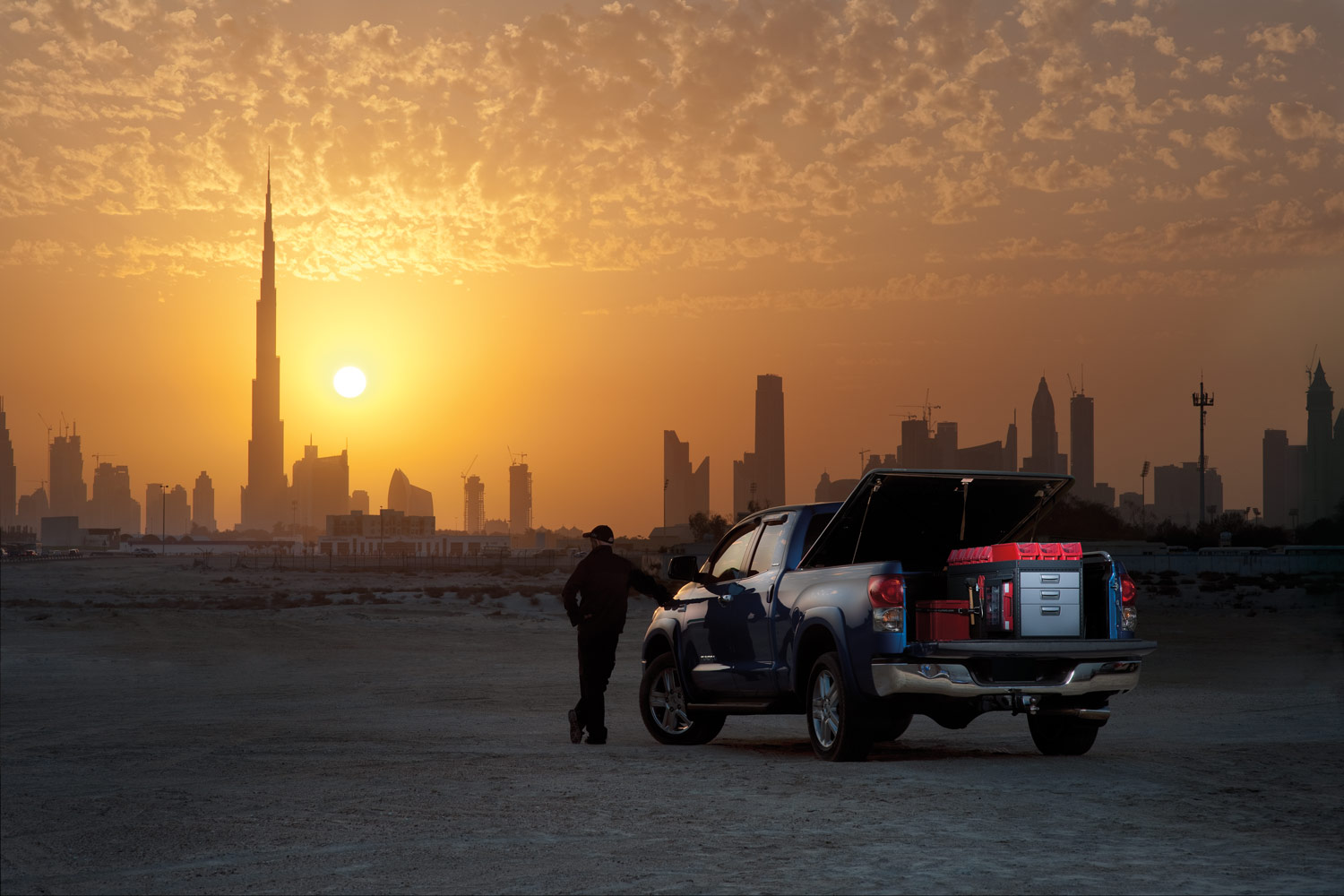 Arbetarens svarta pickup truck med bilinredning från Modul-System i solnedgången i en öken